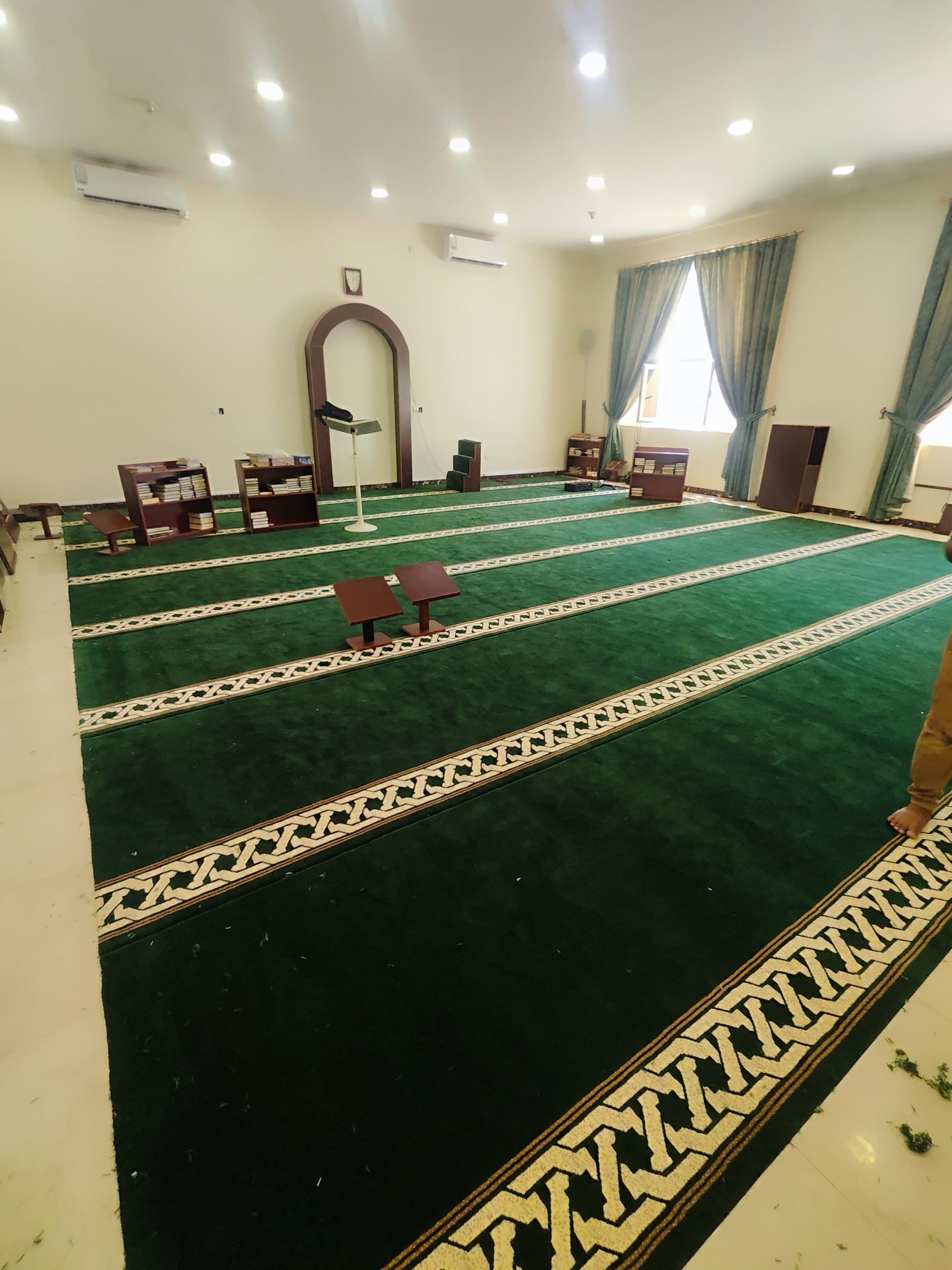 Mosque carpet installation with prayer rows being set to the qiblah in Qatar